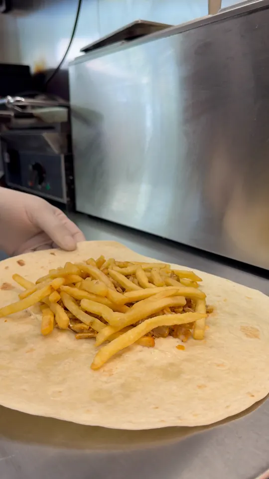 Tacos garni de frites en préparation