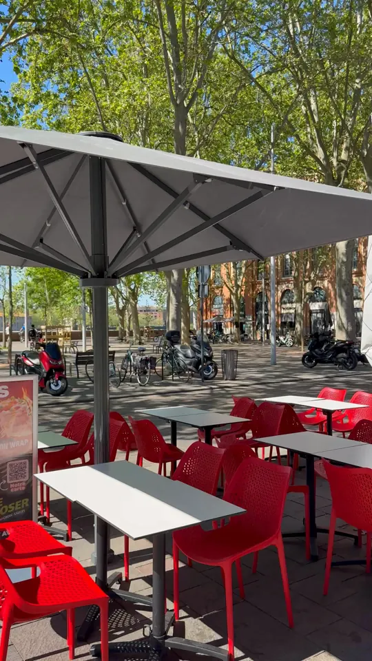 Terrasse aux chaises rouges en plein soleil